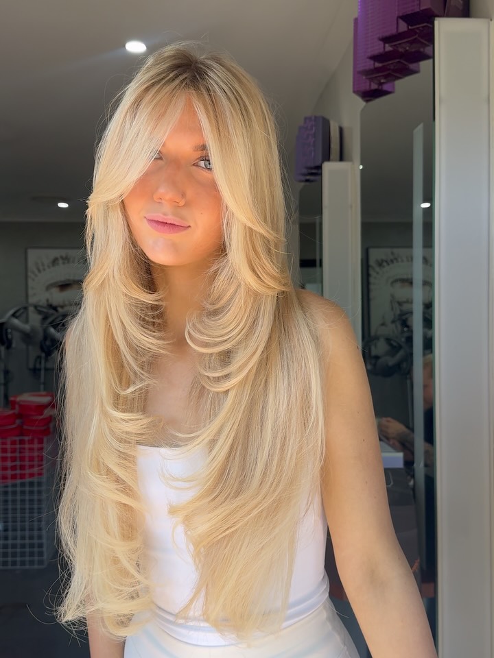 Layered bombshell blonde with soft face-framing pieces at La Mode Gympie
