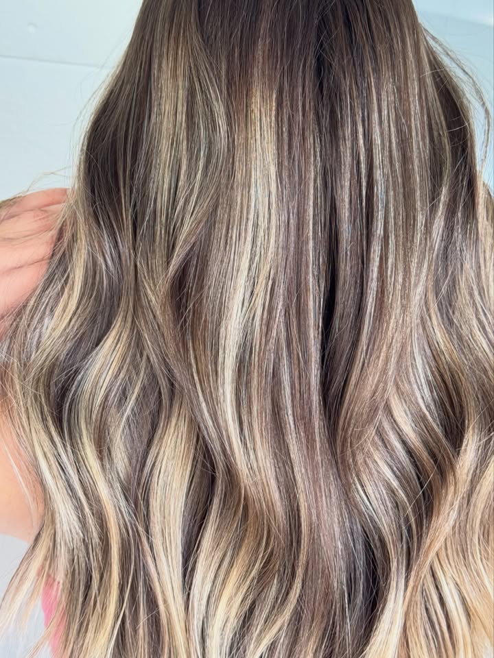 Glossy dimensional brunette with soft curls at La Mode Gympie